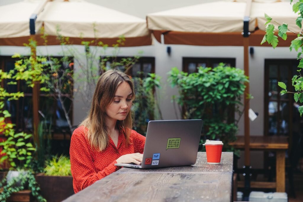 Freelancer working on laptop at outdoor cafe - best accounting software for freelancers