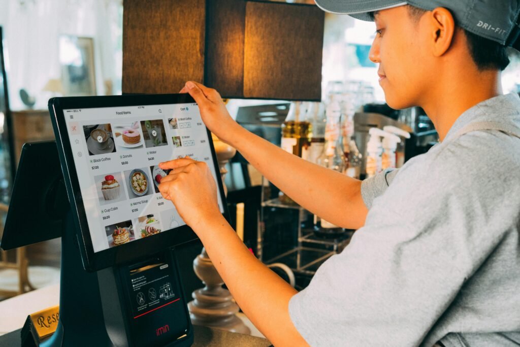 A cafe worker navigating a modern touchscreen system to manage orders efficiently.