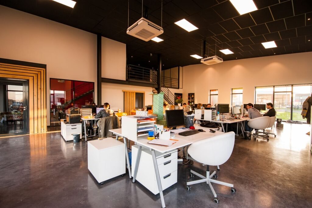 Open-plan creative agency office with employees working at desks under natural light