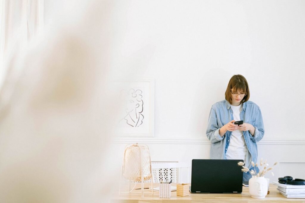 Self-employed woman managing business banking on her smartphone in a home office
