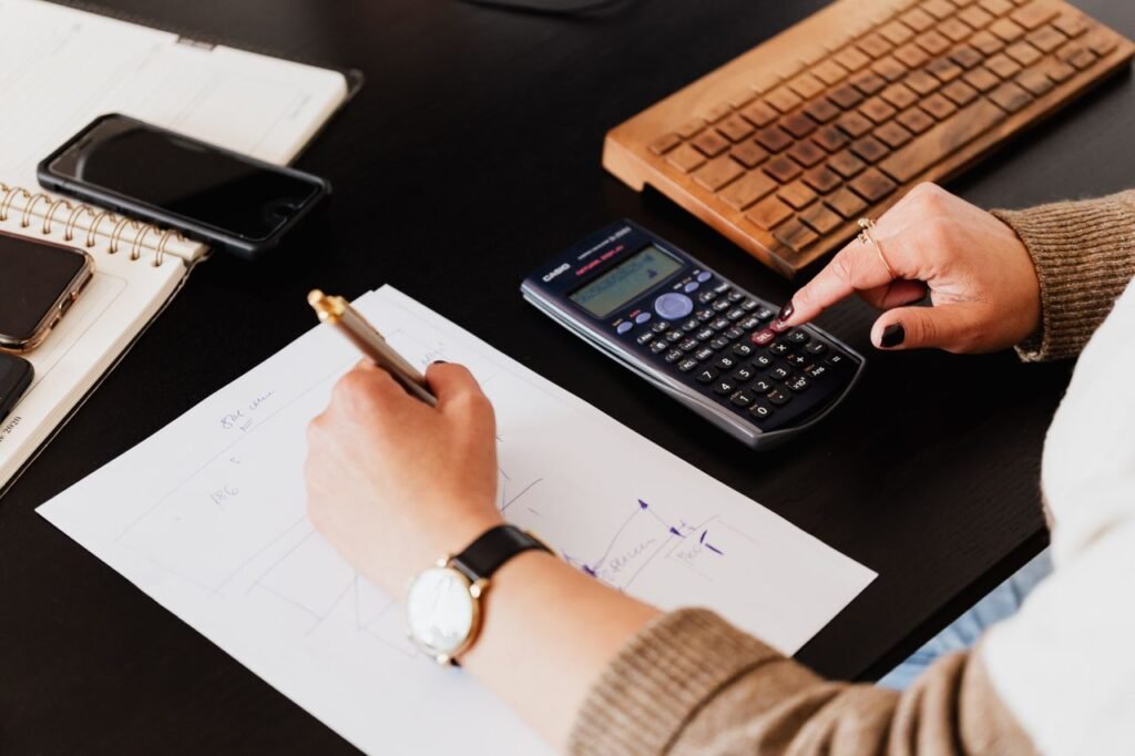 Bookkeeper working at a desk with a calculator and financial paperwork