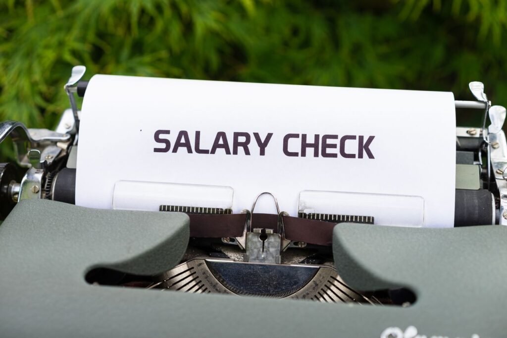 Vintage typewriter typing the words salary check, representing small business payroll