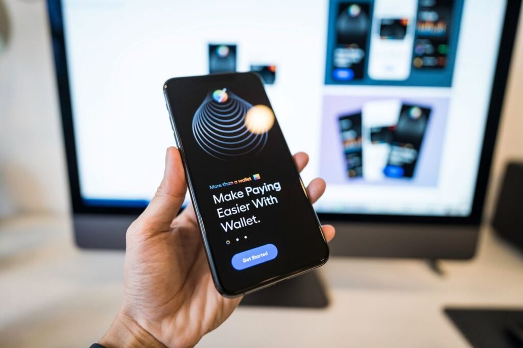 Hand holding a smartphone showing a mobile banking app used for business finances