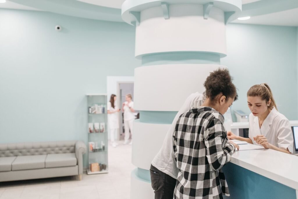 Healthcare professionals assisting a patient at a modern medical office reception desk