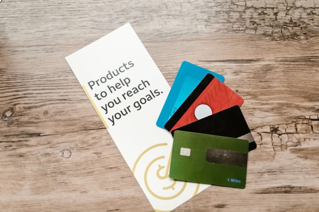 Several business credit cards arranged on a wooden table next to financial planning documents