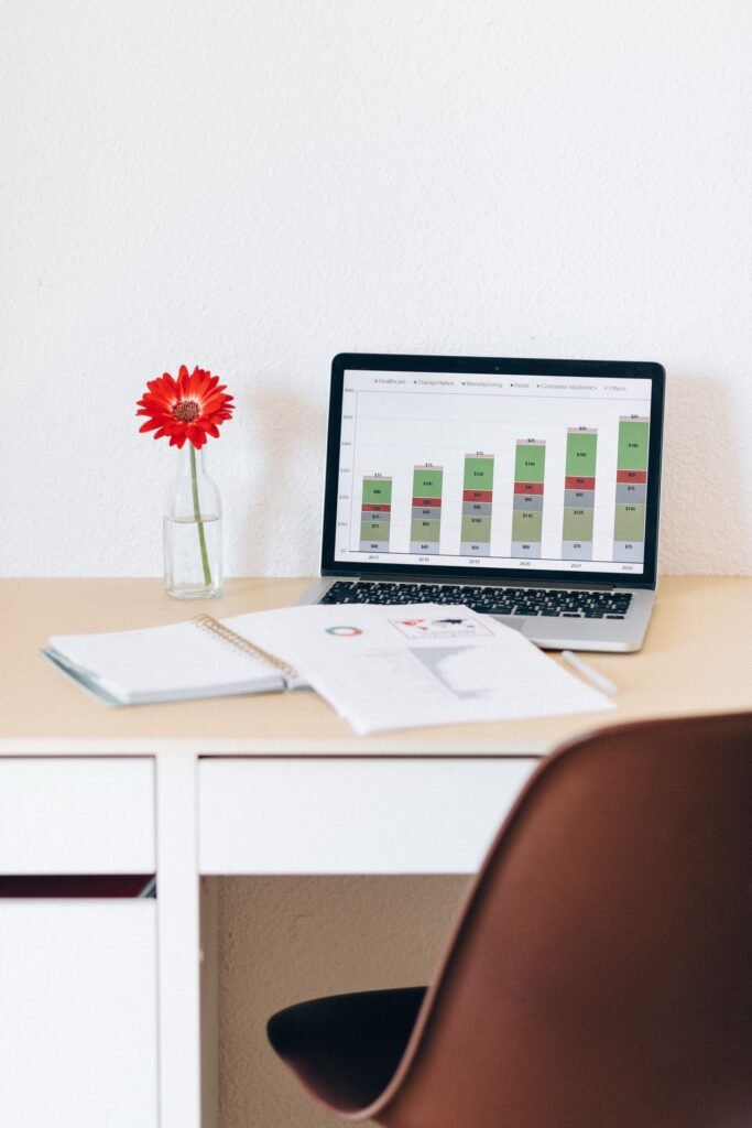 Desk with a laptop displaying financial charts, used to compare accounting software