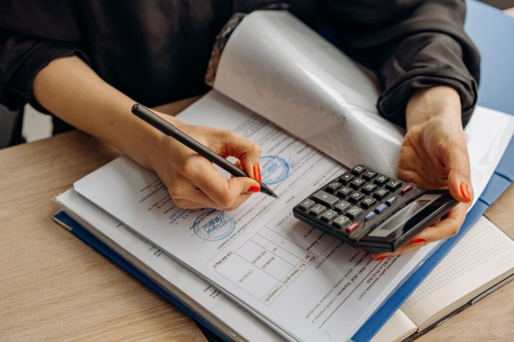 Accountant examining financial documents with a calculator at a desk
