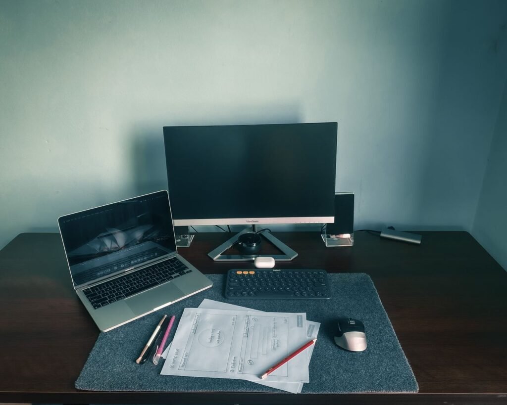 Home office desk setup with laptop, monitor, and paperwork used for a home-based business